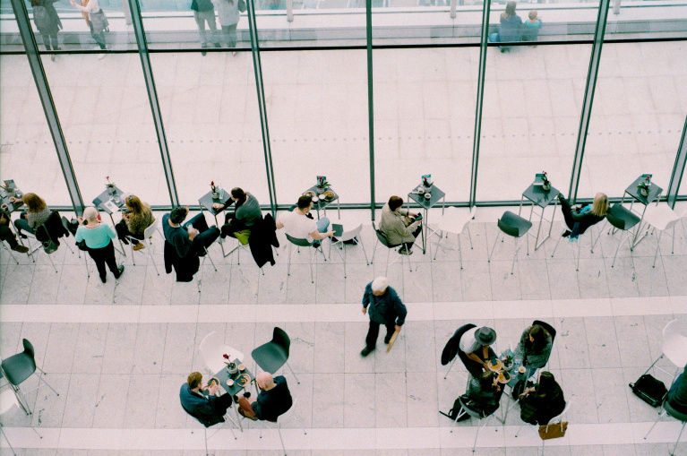 Overhead view of people communicating around cafe tables